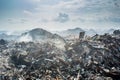 Refuse at the garbage dump with lot of smoke, litter, plastic bottles,rubbish and trash at tropical island