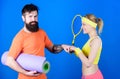 Refuse to Lose. Sporty couple training with fitness mat and tennis racket. Happy woman and bearded man workout in gym