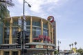 Regal LA Live on Olympic Blvd with cars and trucks driving on the street, traffic signals, light posts, blue sky and clouds