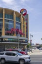 Regal LA Live on Olympic Blvd with cars and trucks driving on the street, traffic signals, light posts, blue sky and clouds