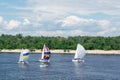 Regatta competition on lake river sailing yachts boats with sails and multicolored gennakers, reflected sky in water