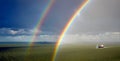 Sun, rain and a double rainbow. Royalty Free Stock Photo