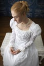 A Regency woman wearing a white cotton muslin dress and standing in a room Royalty Free Stock Photo