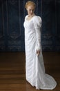 A Regency woman wearing a white cotton muslin dress and standing in a room Royalty Free Stock Photo