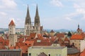 Spires of the St. Peter Cathedral above historical buildings roofs over the blue sky in Regensburg, Germany.