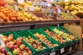 Regensburg, Germany - 2021 02 05: Various sorts of unpacked apples and other fruits in green plastic boxes and baskets on display