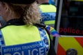 Close up police woman with rainbow colours painted on her face, and wearing a rainbow flag on her shoulder at the Gay Pride Parade