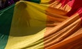 Close up of the giant rainbow LGBT flag. Silhouette of woman can be through the flag. Photographed in strong sunlight.