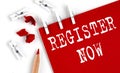 REGISTER NOW text on red paper with office tools on white background Royalty Free Stock Photo