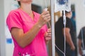 Registered nurse wearing hot pink scrubs hangs IV Royalty Free Stock Photo