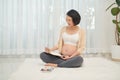 Regnant woman lie down looking at a sonogram ultrasonography picture of her unborn baby