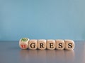 Regress or progress symbol. Turned wooden cubes and changes the word Regress to Progress.