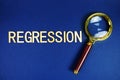Regression alphabet letters with magnifying glass on navy blue background Royalty Free Stock Photo