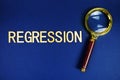 Regression alphabet letters with magnifying glass on navy blue background Royalty Free Stock Photo