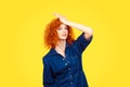 Regrets wrong doing. Closeup portrait silly young redhead curly woman slapping hand on head having duh moment isolated yellow