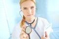 Regular check-ups ensures good health. Portrait of a pretty nurse holding up a stethoscope while holding a medical file. Royalty Free Stock Photo