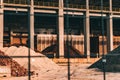 Regular footage of a construction with piles of cement, soil, stone and with pillars