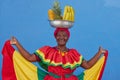 Regular footage of a Palenquera holding bowl of fruits above head, dressed with colorful clothes