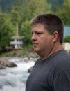 Regular guy meditating and thinking near the river Royalty Free Stock Photo