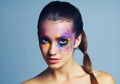 Regular just doesnt do it for me. Studio shot of an attractive young woman with brightly colored makeup against a blue