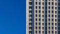 Regular pattern made of rectangular windows on block of flats / offices building. Clear sky place for text on left side Royalty Free Stock Photo