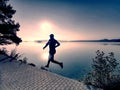 Regular run at lake. Man runner sprinting outdoor in scenic nature