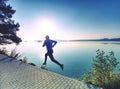 Regular run at lake. Man runner sprinting outdoor in scenic nature