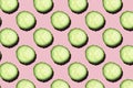 Regular seamless creative pattern of cucumber slices on a pink background