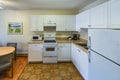 Regular white kitchen with the table and chairs in dinner area.