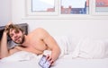 Regulate your bodys clock. Man unshaven tousled hair wakeful face having rest. Good morning. Man unshaven lay bed hold Royalty Free Stock Photo