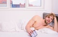 Regulate your bodys clock. Man unshaven tousled hair wakeful face having rest. Good morning. Man unshaven lay bed hold Royalty Free Stock Photo