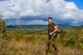 Regulation of hunting. Man muscular brutal guy gamekeeper nature background. Hunter rifle gun stand top of mountain. Guy Royalty Free Stock Photo