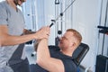 Rehab therapy for patient with handicap. Young man on stretch machine Royalty Free Stock Photo