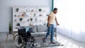 Rehabilitation concept. Young black guy walking with crutches after using wheelchair at home, panorama Royalty Free Stock Photo