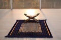 Rehal with open Quran on Muslim prayer rug