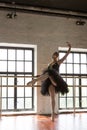 Rehearsal ballerina in the hall. Wooden floor, large windows. Beautiful ballerina in the rehearsal room