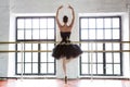 Rehearsal ballerina in the hall. Wooden floor, very large windows. Beautiful ballerina in the rehearsal room.