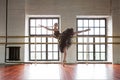 Rehearsal ballerina in the hall. Wooden floor, large windows. Beautiful ballerina in the rehearsal room