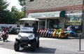 Rehoboth Beach, Delaware, U.S - August 12, 2023 - An electric cart and colorful scooters parked on the street by Scooter City