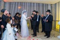 Rehovot, Israel - 11.01.2019. Jewish groom puts the ring on bride`s finger surrounded by relatives on Jewish chasid wedding