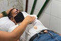 Hand applying reiki and energy therapies to a young woman lying in the treatment room