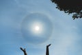 Reiki meditation. Sun in hands. Atmospheric optical effect circle around the sun on hot summer day. Atmospheric halo