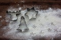 Reindeer, christmas tree and star gingerbread cookie cutters and flour like a snow on wooden background. Christmas food background Royalty Free Stock Photo