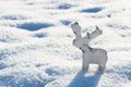 Reindeer figurine made of wood in the snow