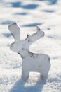 Reindeer figurine made of wood in the snow