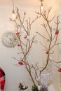 Reindeer garland, dry tree with red berries, snowflakes, clock. Happy New Year inscription on wall. Living room corner decorated Royalty Free Stock Photo