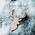 Reindeer head on the snow and text happy holidays