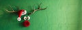 Reindeer with red nose and Santa hat on vibrant green wall background with copy space. Royalty Free Stock Photo