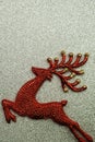 Reindeer and white berry Christmas decoration on silver glitter background