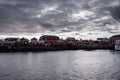 Reine in Lofoten Islands, Norway, with traditional red rorbu huts under misty sky with clouds Royalty Free Stock Photo